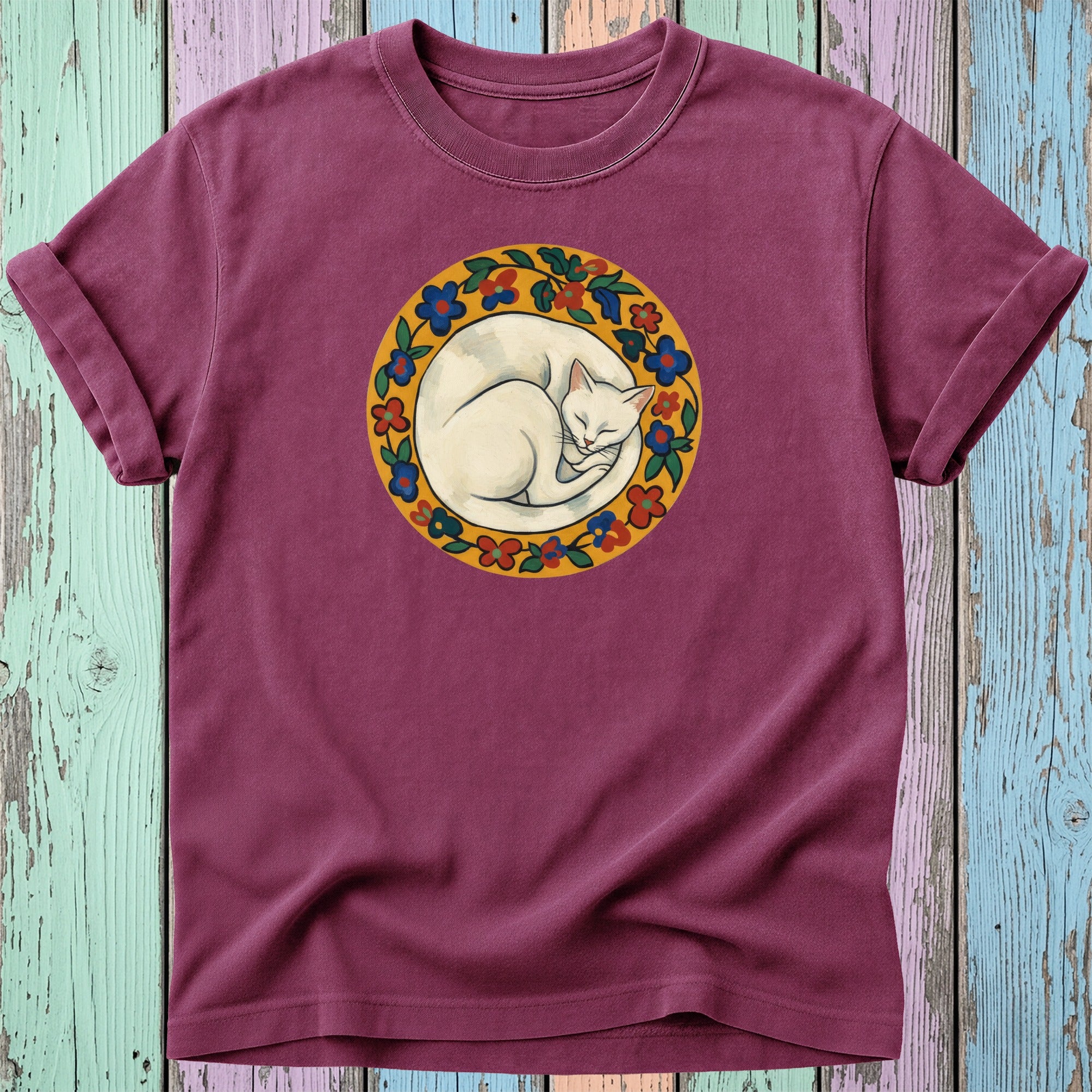 Maroon t-shirt featuring a white cat curled inside a circular floral border.