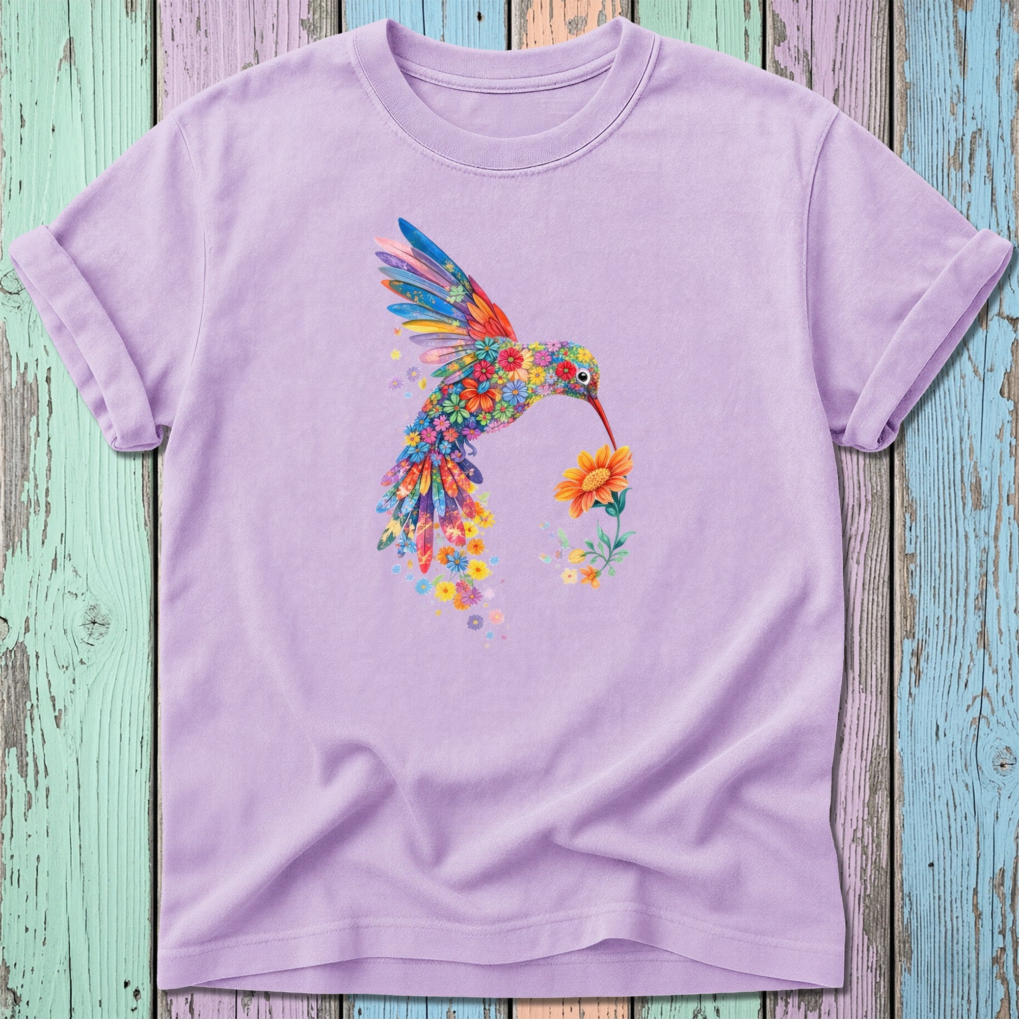 Lavender t-shirt with colorful floral hummingbird holding a yellow flower.