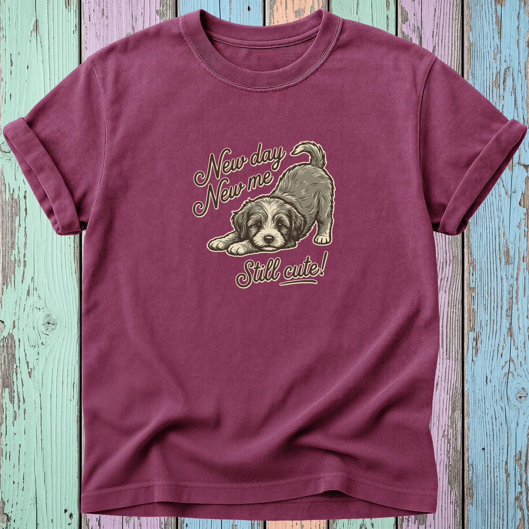 Maroon t-shirt with a drawing of a puppy and text "New day New me Still cute!".
