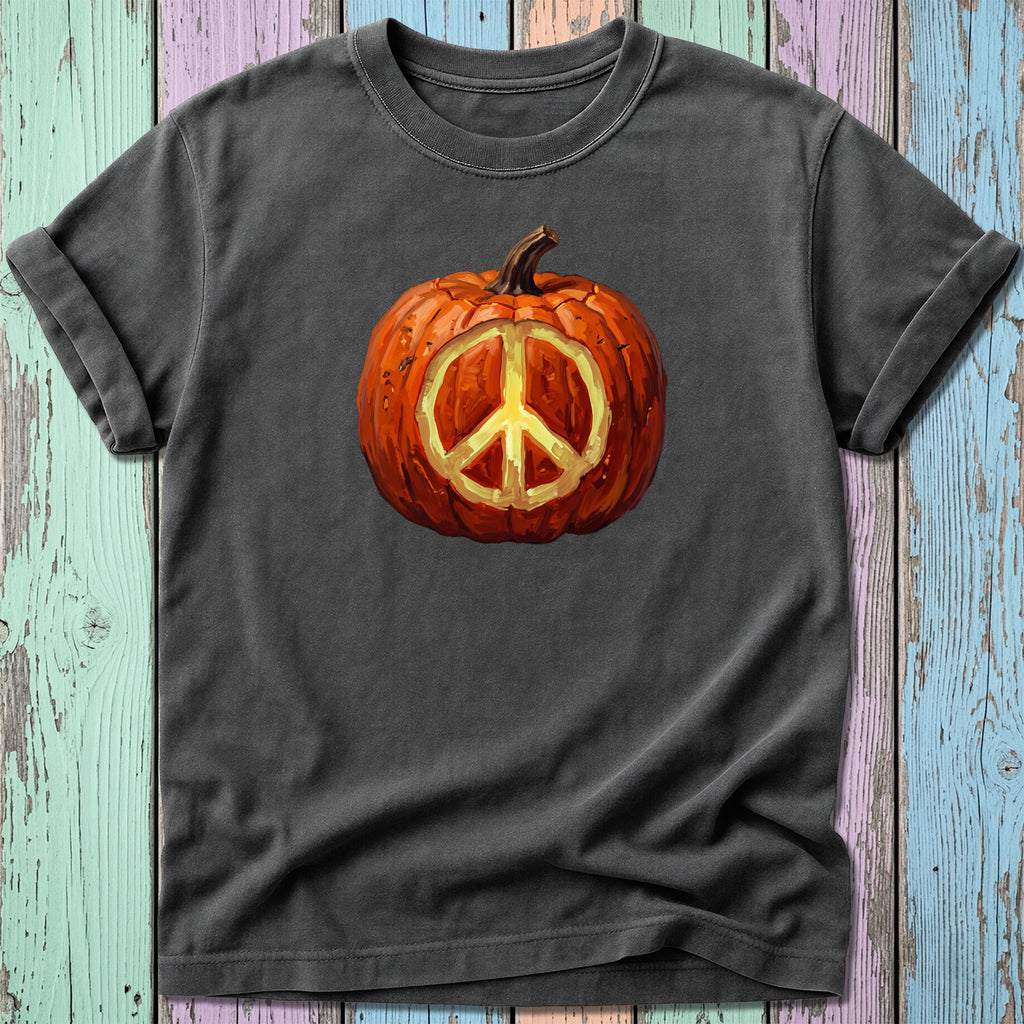 Dark t-shirt with a painted pumpkin featuring a glowing peace sign in the center.