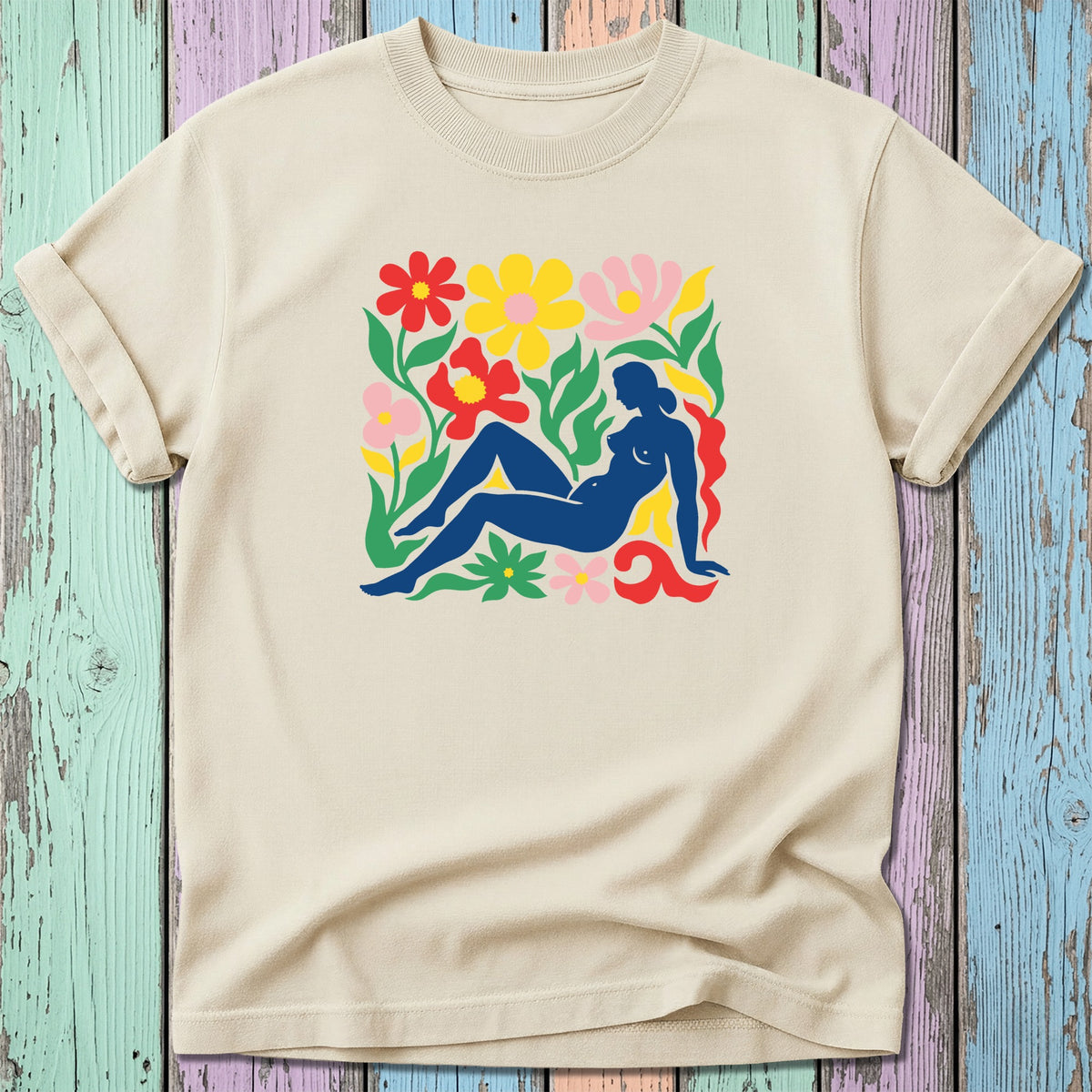 Nude silhouette against colorful floral collage on cream t-shirt.
