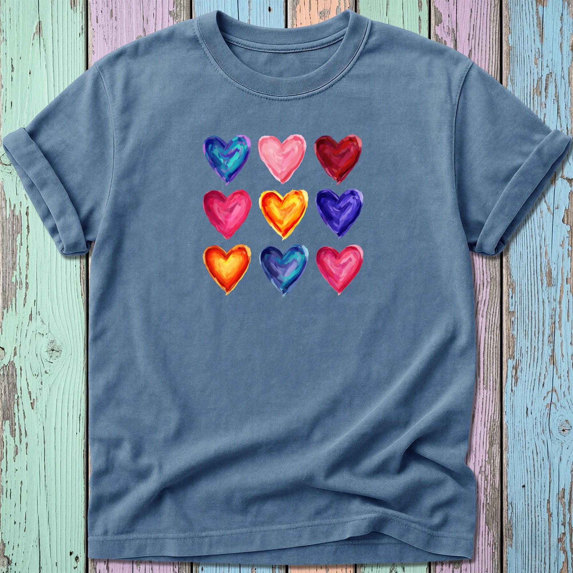 Blue t-shirt with a grid of nine colorful watercolor hearts.