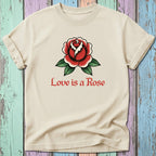 Cream t-shirt with a red rose tattoo design and "Love is a Rose" text.