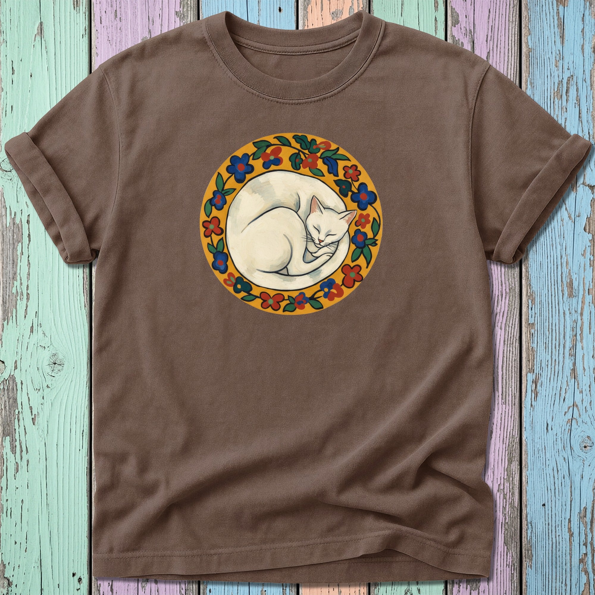 Brown t-shirt with a circular floral design featuring a sleeping white cat.