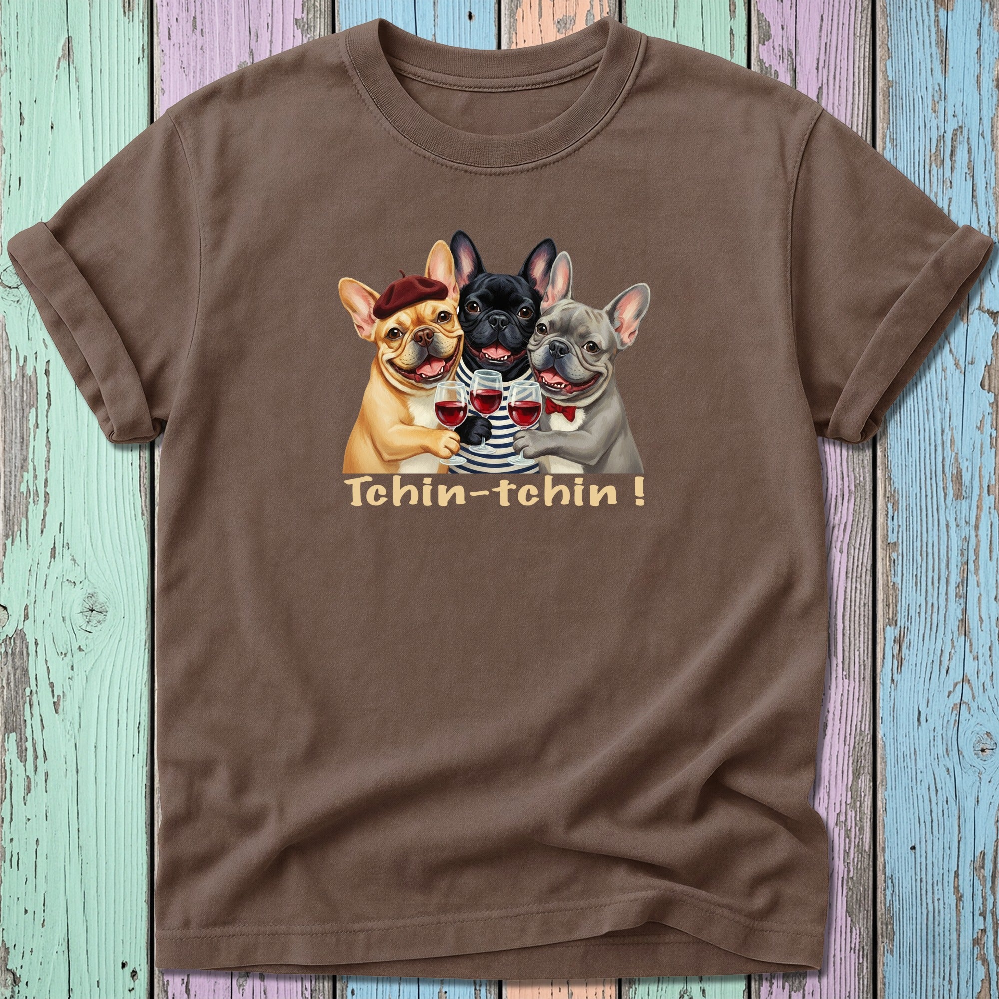 Three French bulldogs in berets and sweaters toast with wine glasses.