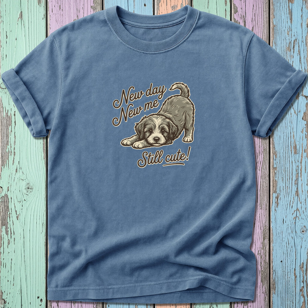 Blue t-shirt with a drawing of a dog and text that reads "New day New me Still cute!"