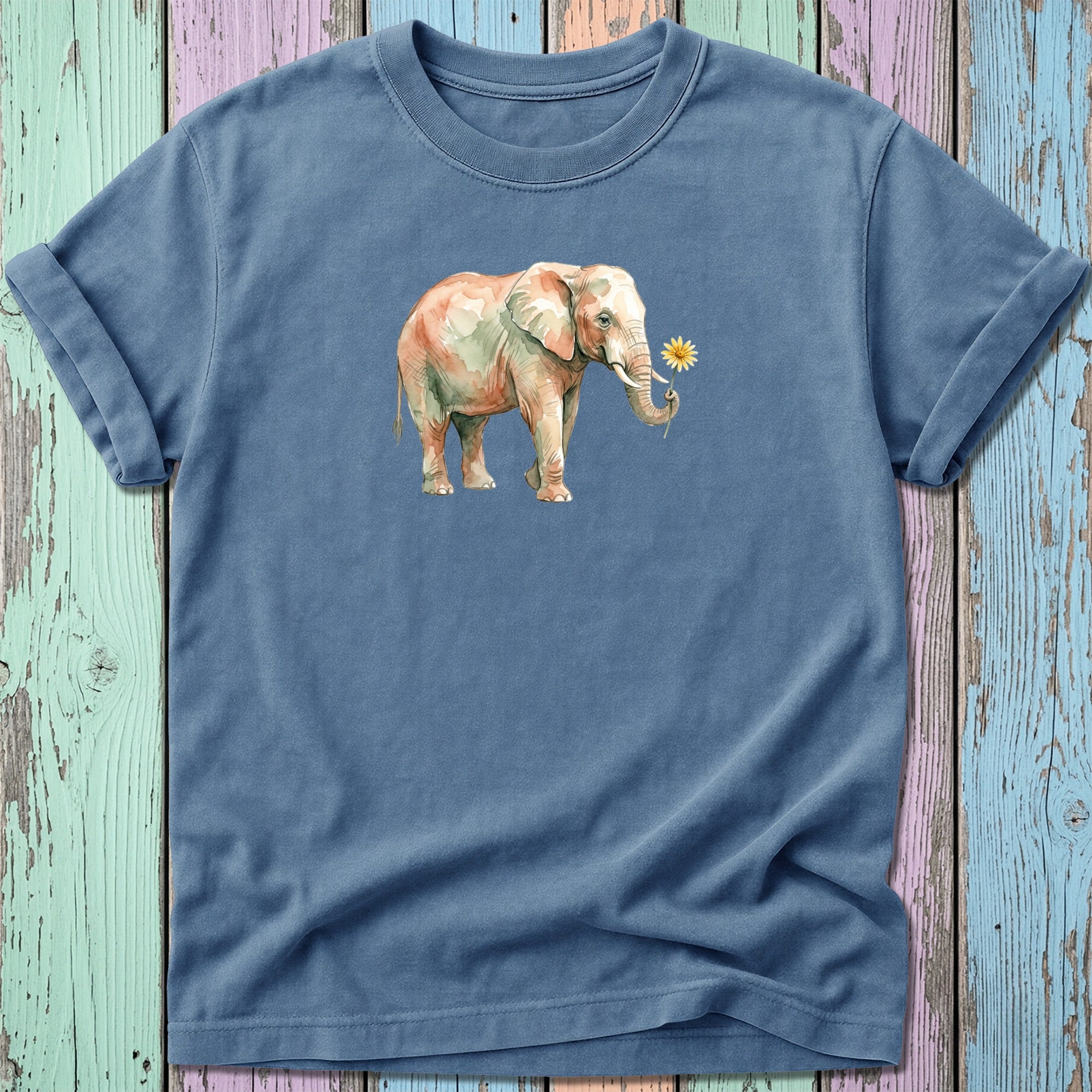 Watercolor elephant with a flower in its trunk on a blue t-shirt.