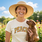 Lifestyle of woman with dog wearing a Cream t-shirt with "PEACE" in a colorful floral graphic