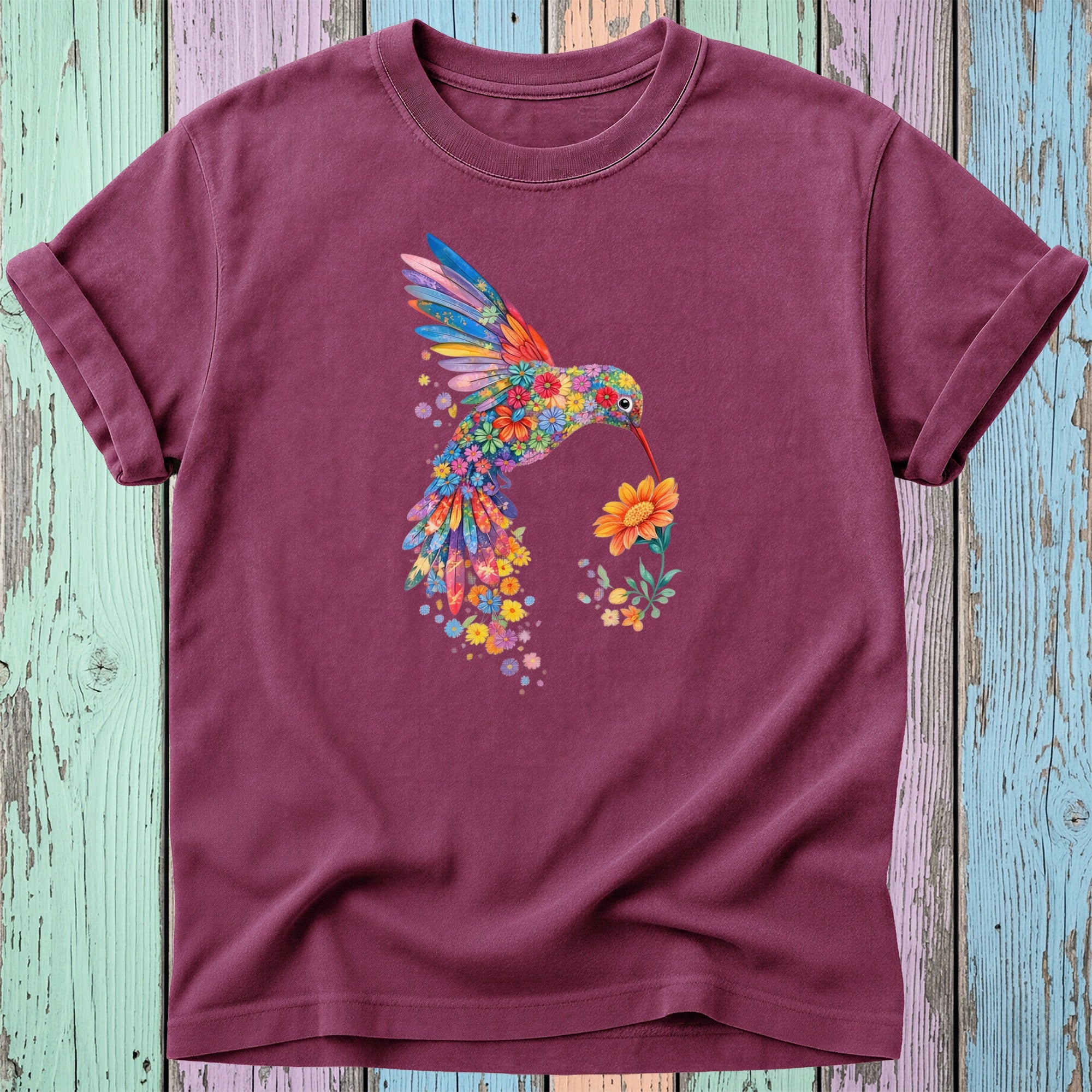 Maroon t-shirt with a colorful floral hummingbird holding a flower.