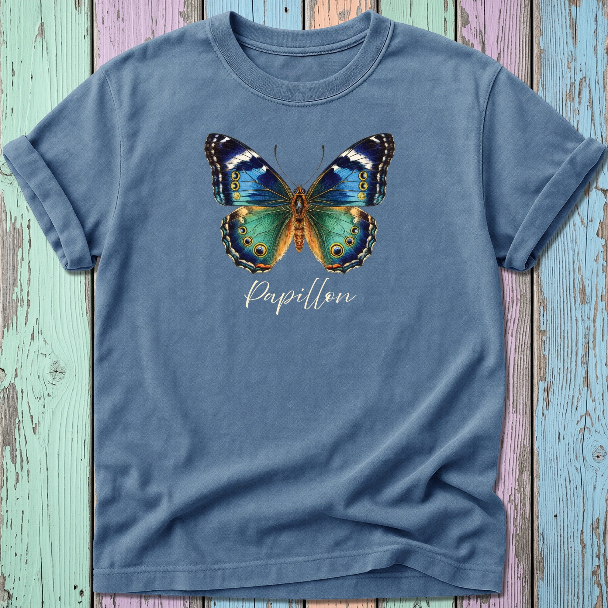 Blue and green butterfly with "Papillon" text on a muted blue t-shirt.