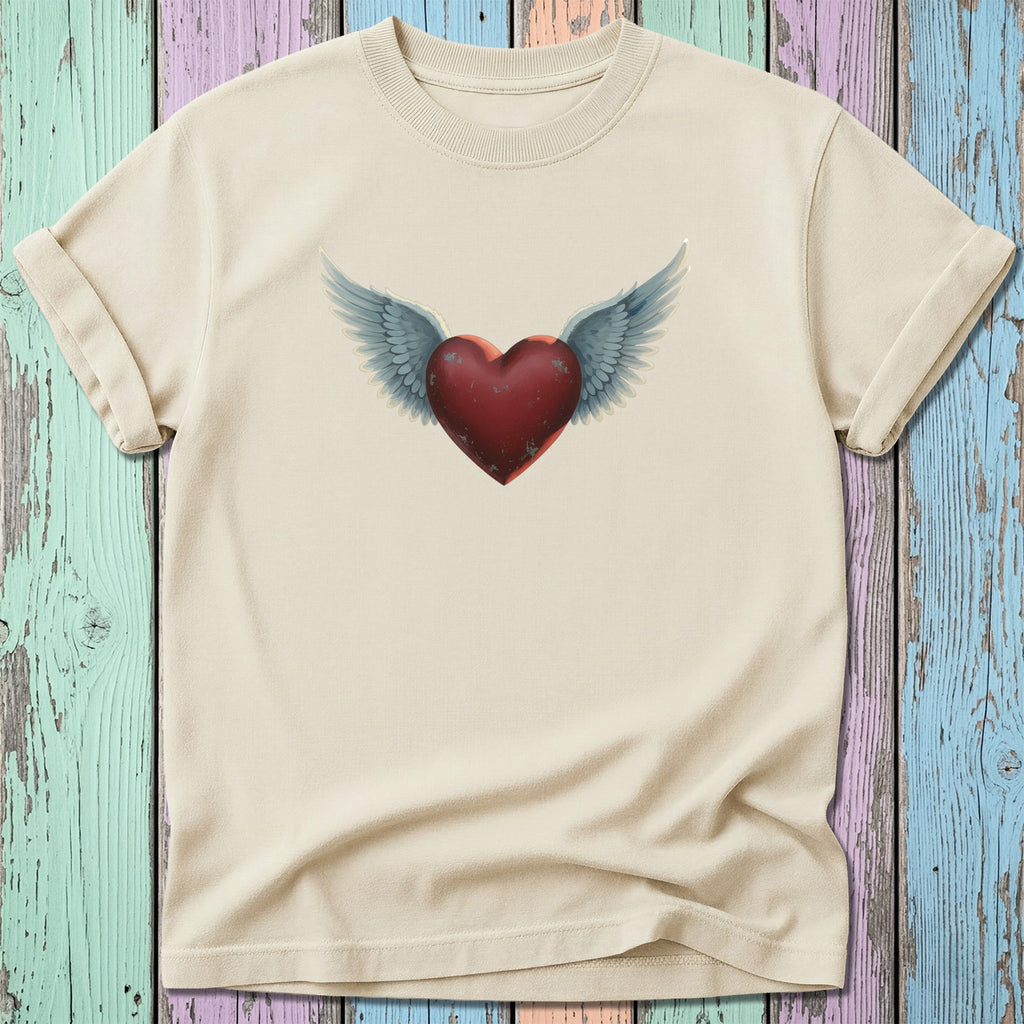 Cream t-shirt with distressed red winged heart graphic on a colorful wooden background.