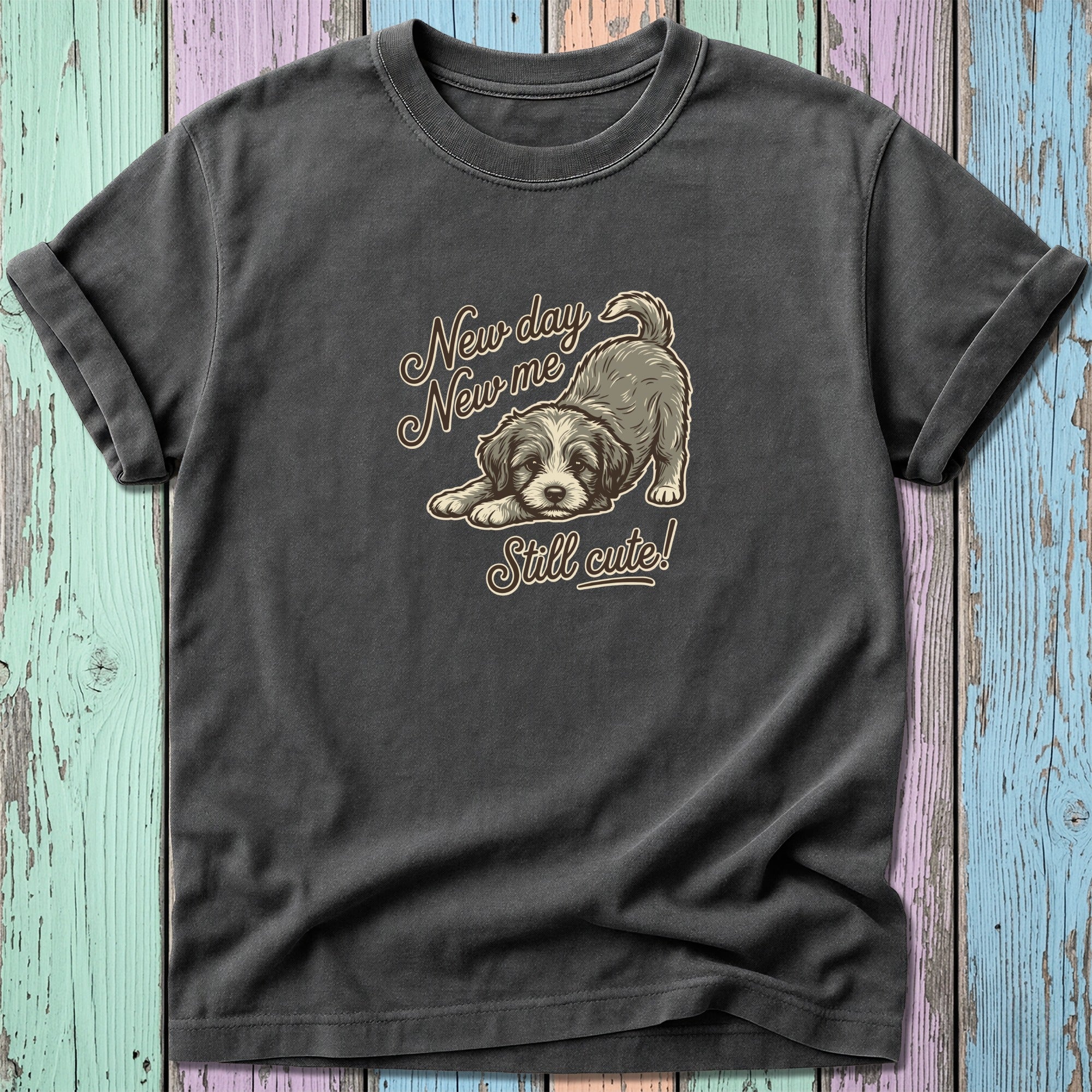 Dark t-shirt with a graphic of a puppy and text "New day New me Still cute!".