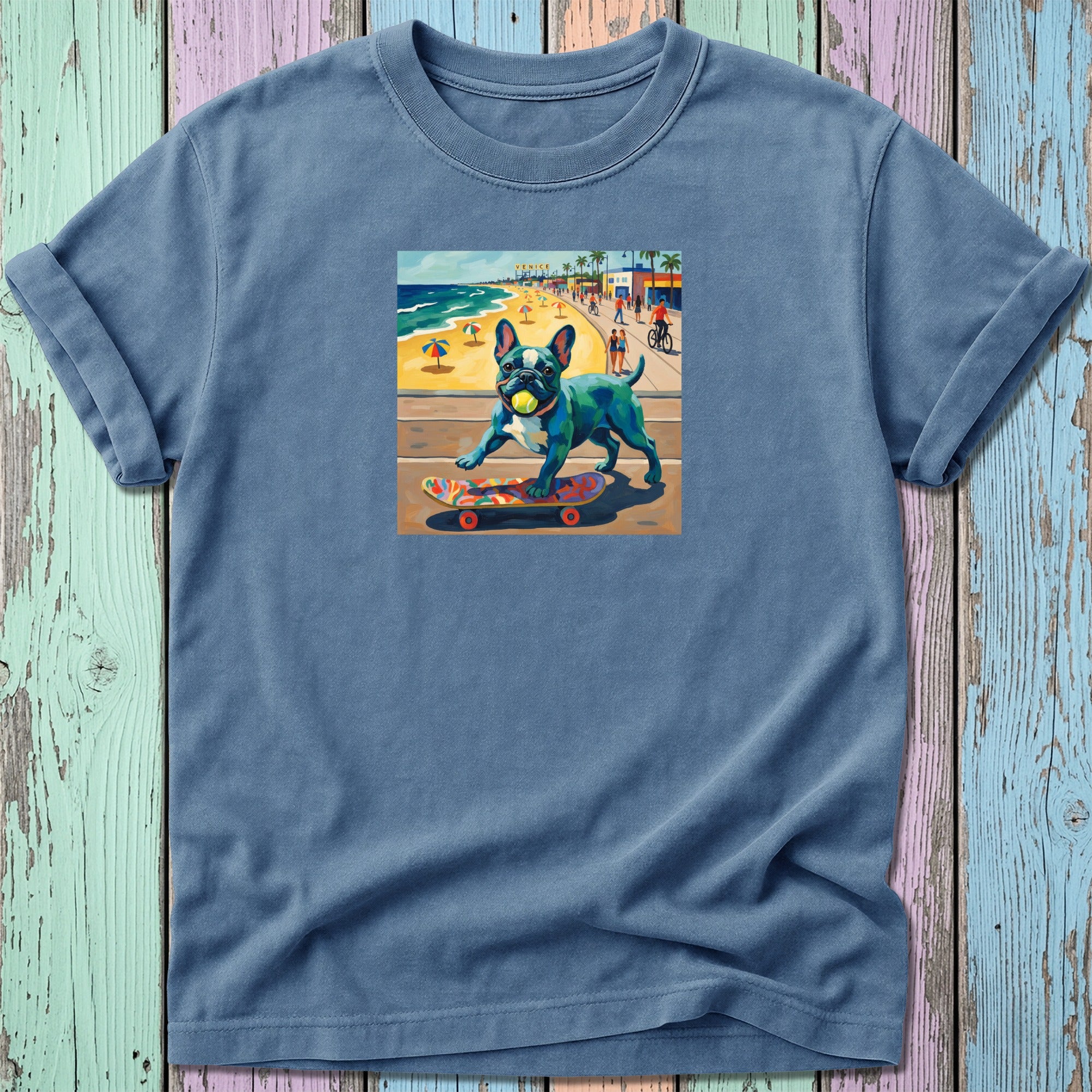 Blue t-shirt with colorful French bulldog on skateboard art.