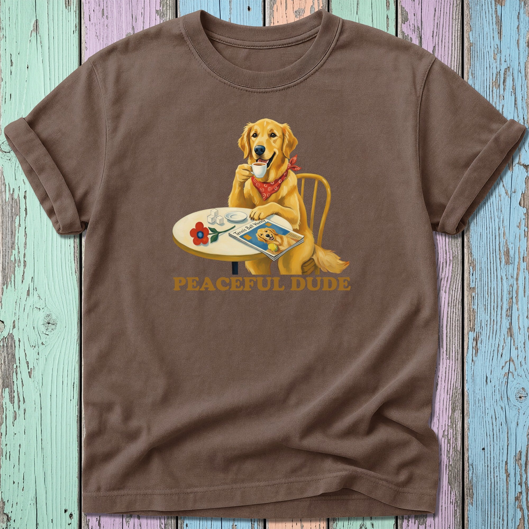 Brown t-shirt with Golden Retriever in bandana drinking coffee at table.